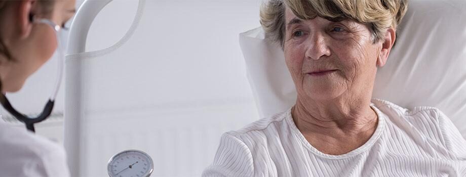 woman in bed being examined by doctor