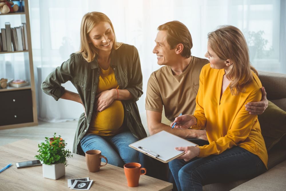 Pregnant surrogate in discussion with couple